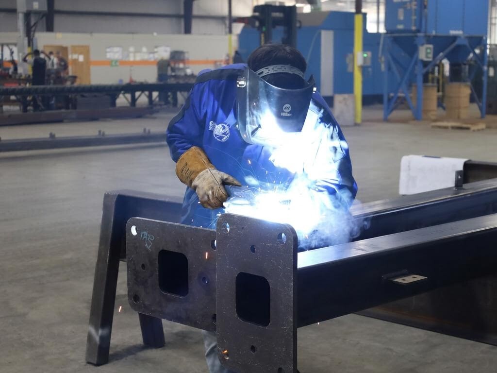 SteelCon welder wearing protective leather gloves while welding a structural steel assembly